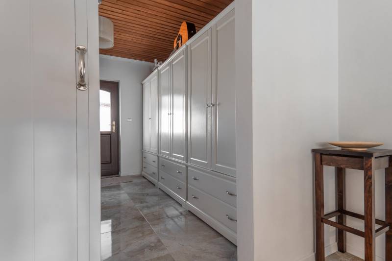Stavebný pozemok 8 500 m² s podnikateľským potenciálom - Chodba so skrinkami, svetlými obkladmi a dreveným stropom v nehnuteľnosti na bývanie.