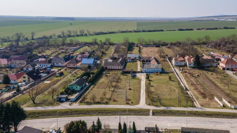 Stavebný pozemok 8 500 m² s podnikateľským potenciálom - Letecká fotografia vidieka v Dolnom Lopašove so záhradami a poľami. Pozemky - bývanie.