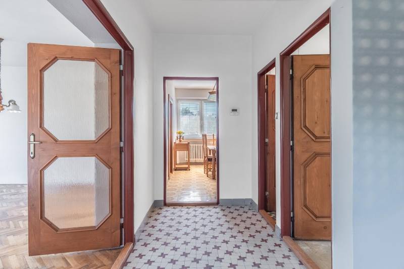 I Na predaj dvojposchodový 5i rodinný dom pri Žiline - Chodba v Rodinnom dome s keramickou dlažbou a drevenými dverami vedúca do jedálne.