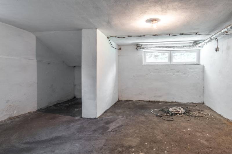 I Na predaj dvojposchodový 5i rodinný dom pri Žiline - Nezariadená pivnica v rodinnom dome so surovou podlahou a jednoduchým osvetlením.
