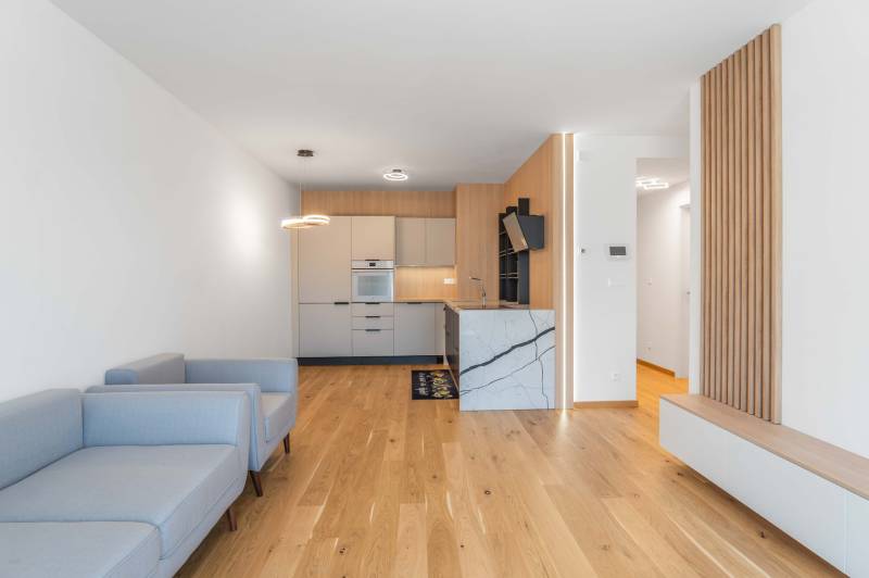 : Nadštandardný 2-i byt v projekte ZWIRN za cenu „štandardu“ - 2-izbový byt s drevenou podlahou, kuchynskou linkou a svetlými sedačkami.