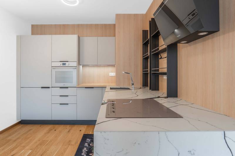 : Nadštandardný 2-i byt v projekte ZWIRN za cenu „štandardu“ - Kuchyňa v 2-izbovom byte so svetlými skriňami a štýlovou pracovnou doskou.