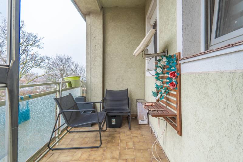 I Na predaj 2-i byt s terasou v Auersthal (Rakúsko) - Balkón 2-izbového bytu v Auersthale na ulici Kirchssen s posedením a kvetinovou dekoráciou.