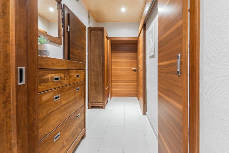 I Na predaj 2-i byt s terasou v Auersthal (Rakúsko) - Vstupná chodba 2-izbového bytu s drevom dekorovanými dverami a skriňou.