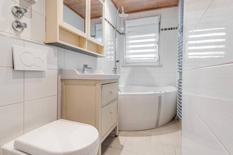 I Na predaj 2-i byt s terasou v Auersthal (Rakúsko) - Kúpeľňa s vaňou, umývadlom, toaletou a oknom v 2-izbovom byte so svetlými obkladmi.