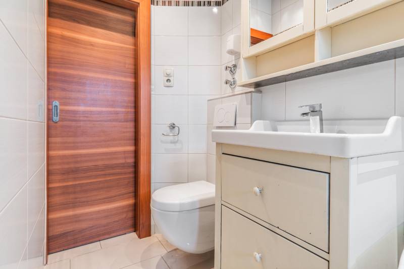 I Na predaj 2-i byt s terasou v Auersthal (Rakúsko) - Kúpeľňa s umývadlom, zrkadlovou skrinkou a toaletou v 2-izbovom byte.