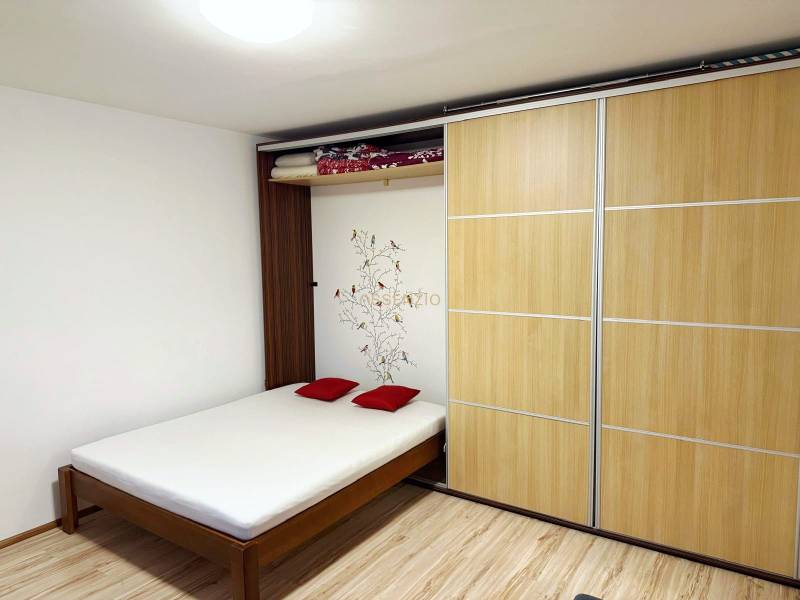 - PRENÁJOM - 1 IZBOVÝ BYT - TOPOĽČIANSKA UL. - PETRŽALKA - Izba s posteľou, šatníkovou skriňou a podlahou s dreveným dekorom.