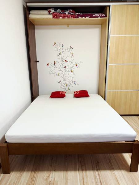 - PRENÁJOM - 1 IZBOVÝ BYT - TOPOĽČIANSKA UL. - PETRŽALKA - Posteľ so stromom na stene a úložným priestorom v 1-izbovom byte.