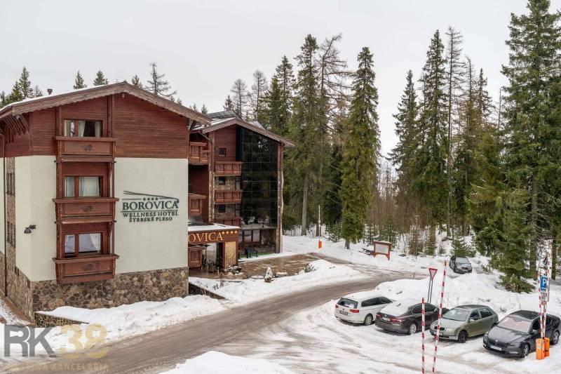 Exkluzívny byt v srdci Vysokých Tatier na Štrbskom Plese - Rekreačný apartmán v Poprade obklopený zasneženým lesom a parkovacím priestorom.