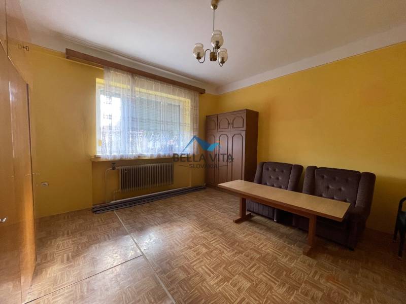 EXKLUZÍVNE - Útulný 3-izbový dom v Čiernom Brode s veľkým pozemkom - Žltá izba v rodinnom dome s dvomi kreslami a stolom, podlaha s dreveným dekorom.