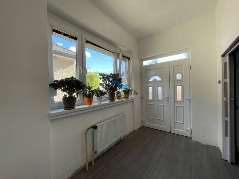 EXKLUZÍVNE - Útulný 3-izbový dom v Čiernom Brode s veľkým pozemkom - Vstupná hala v rodinnom dome s podlahou s dreveným dekorom a rastlinami na parapete.