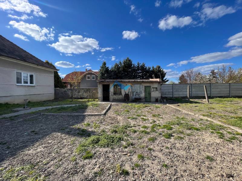 EXKLUZÍVNE - Útulný 3-izbový dom v Čiernom Brode s veľkým pozemkom - Záhrada pri rodinnom dome na ulici Heď v Čiernom Brode s nízkymi stavbami a plotom.