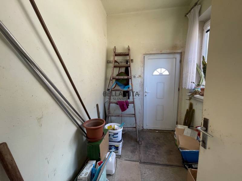 EXKLUZÍVNE - Útulný 3-izbový dom v Čiernom Brode s veľkým pozemkom - Úložný priestor s rebríkom, dverami a kvetmi v rodinnom dome.