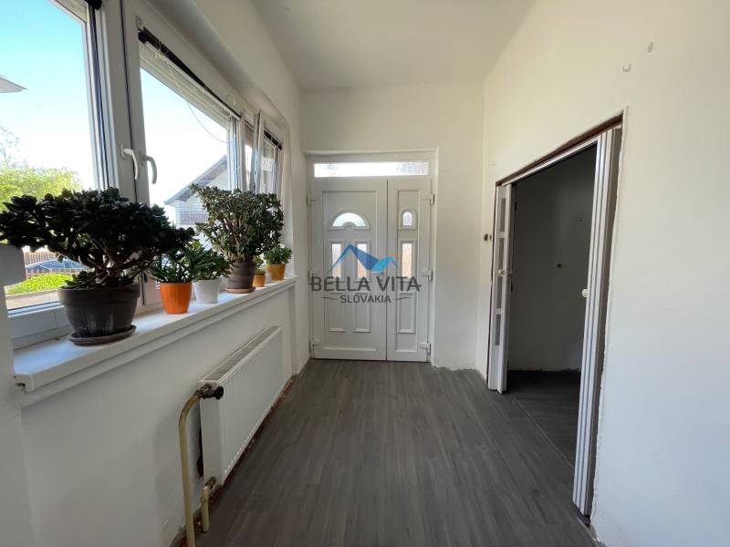 EXKLUZÍVNE - Útulný 3-izbový dom v Čiernom Brode s veľkým pozemkom - Chodba v rodinnom dome s bielymi stenami, podlahou s dreveným dekorom a izbovými rastlinami.