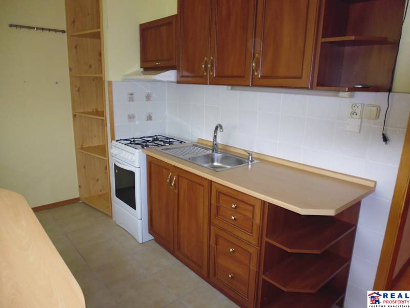 PRENÁJOM: M.NEŠPORA - 2-izbový byt, 58 m2, 7.posch. - Sídlisko III. - Kuchyňa v 2-izbovom byte so skrinkami a bielymi obkladačkami.