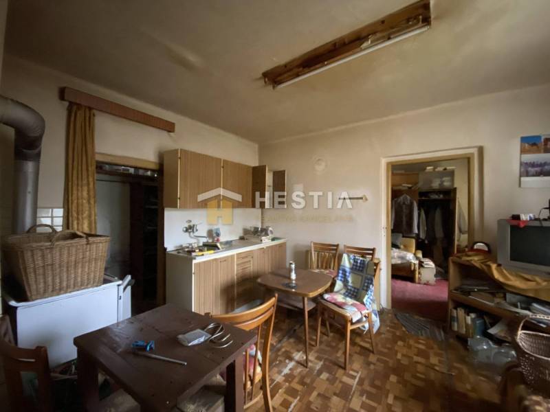 TOP PONUKA !! 3-izb. RD, INVESTÍCIA, Borský Svätý Jur - Kuchyňa v rodinnom dome s dreveným nábytkom, starým televízorom, jedálenským stolom a šatníkom.