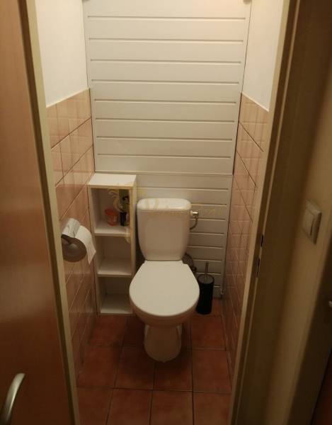 4-izb. byt na ul. Wolkrova, Petržalka, upravený na 2 bytové jednotky - Toaleta s dlažbou, policami a papierovým držiakom v 4-izbovom byte.