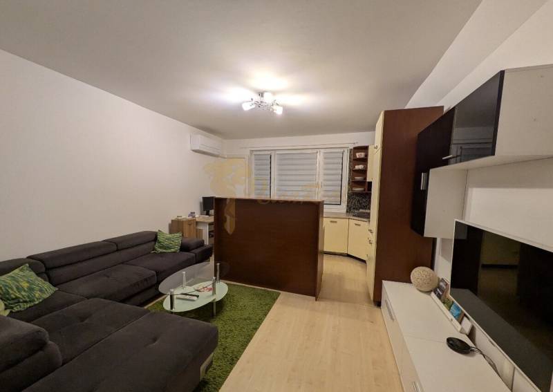 4-izb. byt na ul. Wolkrova, Petržalka, upravený na 2 bytové jednotky - Obývačka v 4-izbovom byte s pohovkou a skleneným stolíkom, podlaha s dreveným dekorom.