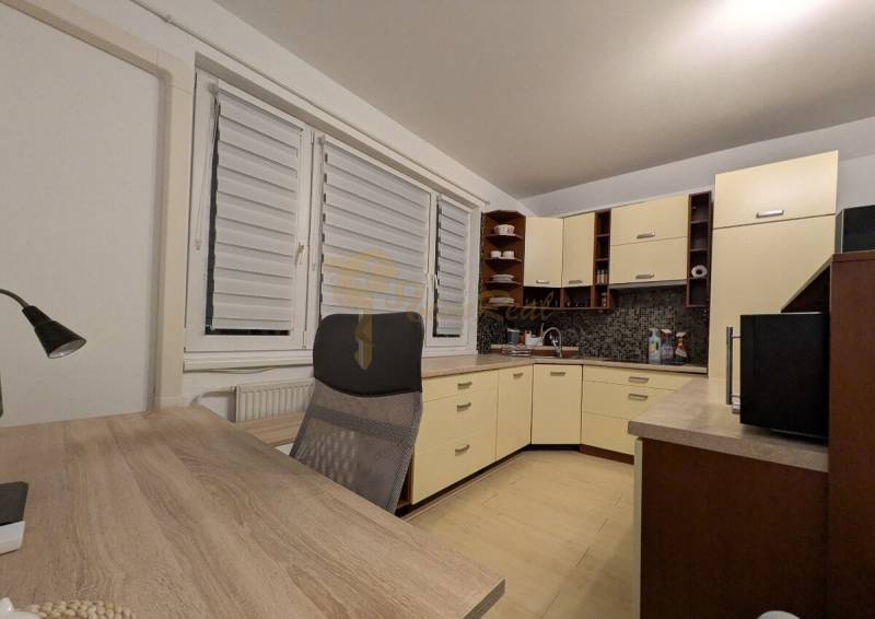 4-izb. byt na ul. Wolkrova, Petržalka, upravený na 2 bytové jednotky - Kuchyňa v 4-izbovom byte s nábytkom, pracovným stolom a podlahou s dreveným dekorom.