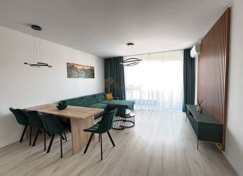 Novostavba 2,5-izb. bytu v NUPPU, garážové státie + vonkajšie státie - Obývacia izba v 2-izbovom byte s rohovou sedačkou a jedálenským stolom.