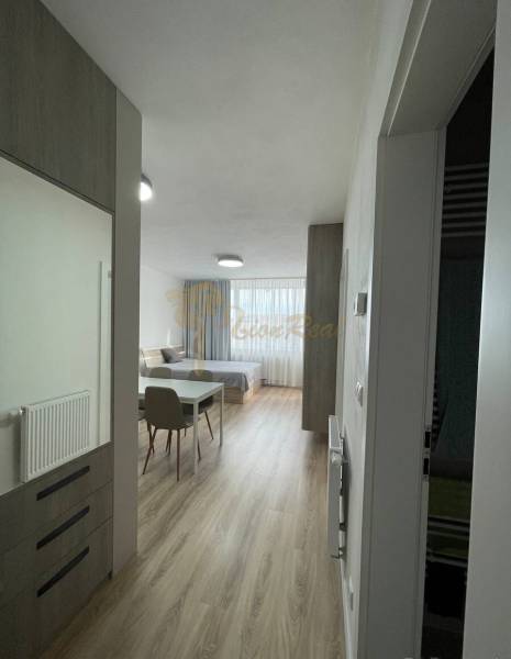 2-izb. byt Bystrická, Devínska Nová Ves, parking, pivnica - V 2-izbovom byte svetlý priestor s posteľou, stolom a drevenou podlahou.