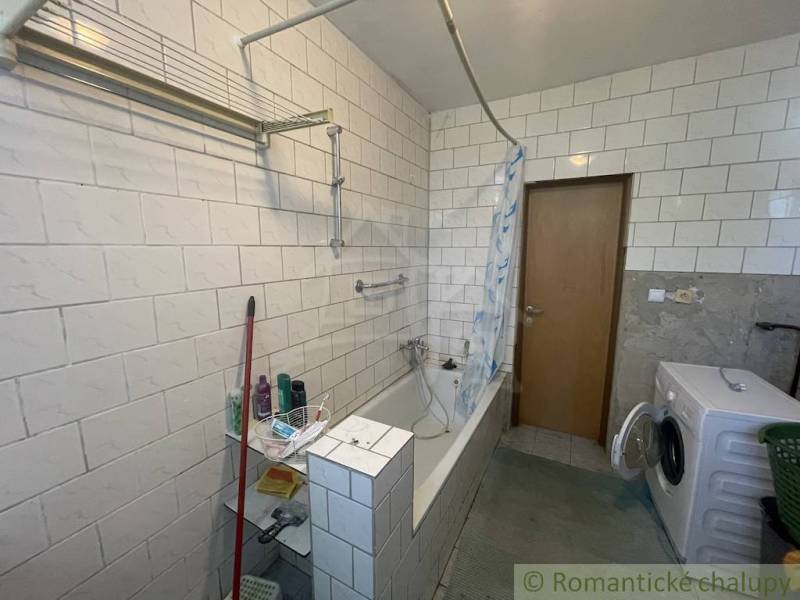 Trojizbový rodinný dom vhodný aj na chalupu v kľudnej časti obce Jatov - Kúpeľňa v rodinnom dome s vaňou, práčkou a kachličkovanými stenami.