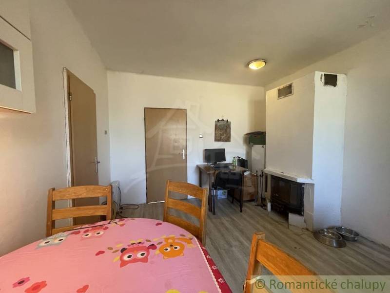 Trojizbový rodinný dom vhodný aj na chalupu v kľudnej časti obce Jatov - Jedáleň v rodinnom dome s dreveným stolom a podlahou s dreveným dekorom.