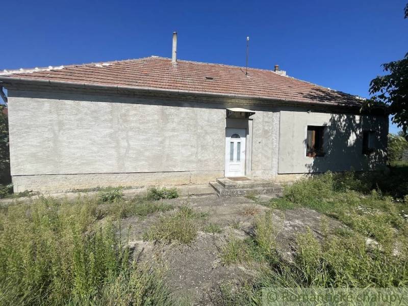 Trojizbový rodinný dom vhodný aj na chalupu v kľudnej časti obce Jatov - Rodinný dom v Jatove s jednoduchou fasádou a okolitou zeleňou.