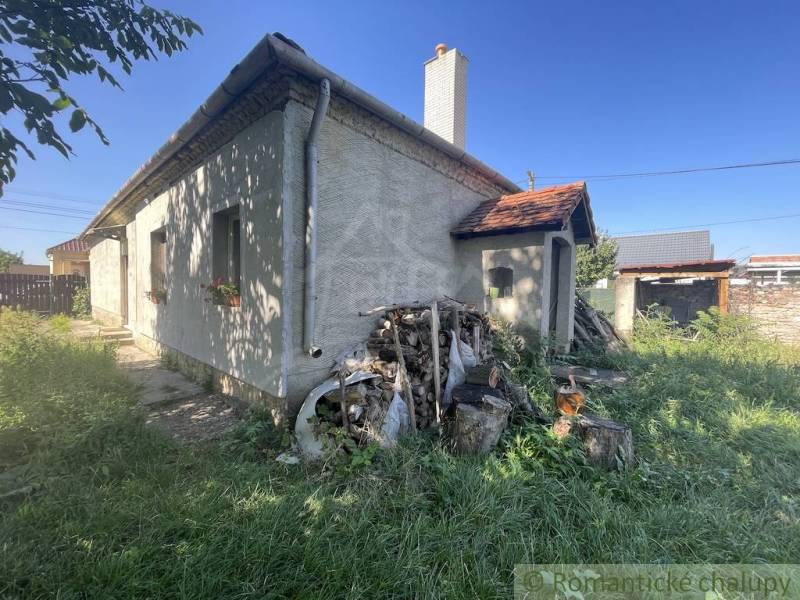 Trojizbový rodinný dom vhodný aj na chalupu v kľudnej časti obce Jatov - Rodinný dom v Jatove s dreveným obkladom a záhradou plnou kvetov a kmeňov.