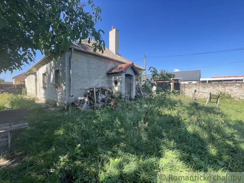 Trojizbový rodinný dom vhodný aj na chalupu v kľudnej časti obce Jatov - Rodinný dom v Jatove s trávnatým dvorom a drevenou hromadou vedľa domu.