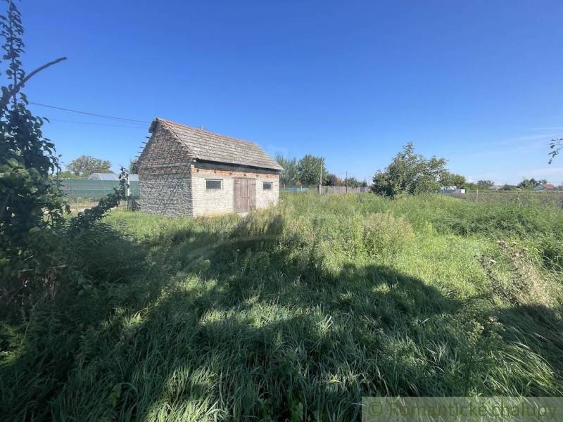 Trojizbový rodinný dom vhodný aj na chalupu v kľudnej časti obce Jatov - Rodinný dom v Jatove obklopený zeleným trávnikom a modrou oblohou.