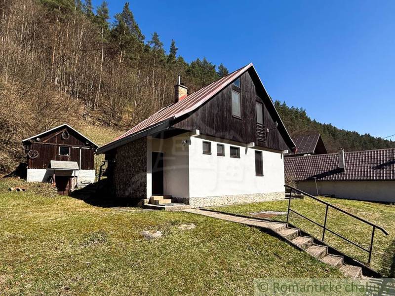 Chalupa - rodinný dom v krásnom prostredí – Moštenica, Banská Bystrica - Chata v Moštenici, obklopená prírodou a lesom, s jasnou oblohou a trávnatým pozemkom.