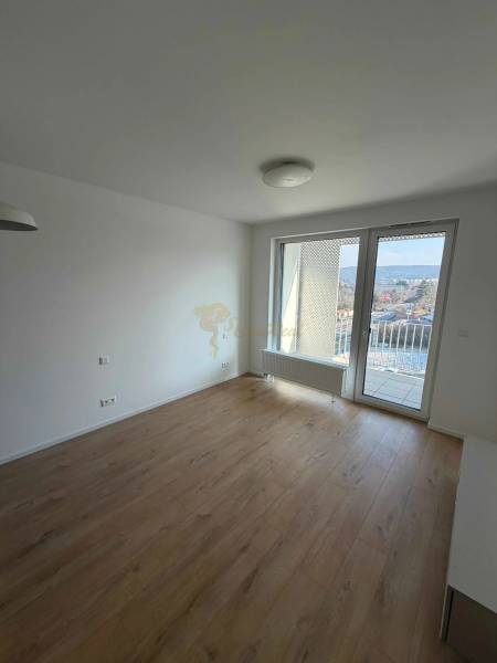 Garzónka v novostavbe AGÁTY, ul. Agátova, Dúbravka, lodžia  - Garsónka s podlahou s dreveným dekorom a balkónovým výhľadom na mesto.