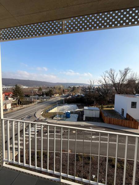 Garzónka v novostavbe AGÁTY, ul. Agátova, Dúbravka, lodžia  - Výhľad z balkóna v Bratislave - Dúbravke na Agátovej ulici s cestou a domami.