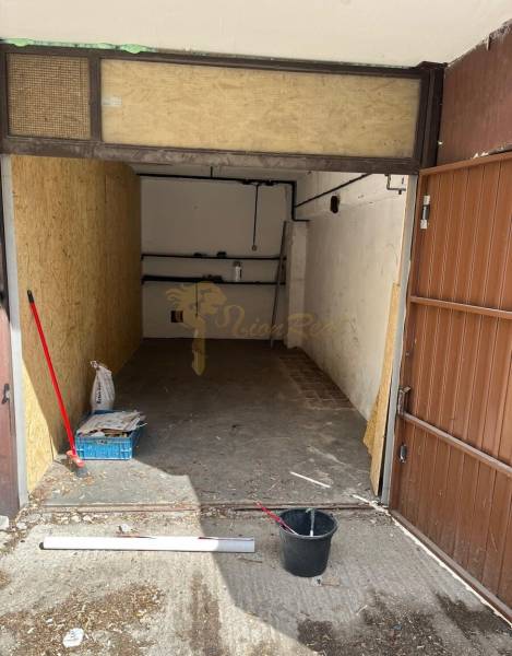 Garáž Rajčianska ul., Vrakuňa - Otvorená garáž na Rajčianskej ulici v Bratislave - Vrakuni s predmetmi na podlahe.