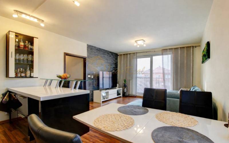 5-izb. byt, Krajinská, Podunajské Biskupice, 2.p./3 - Obývacia izba v 5 a viac izbovom byte s podlahou s dreveným dekorom a jedálenským stolom.