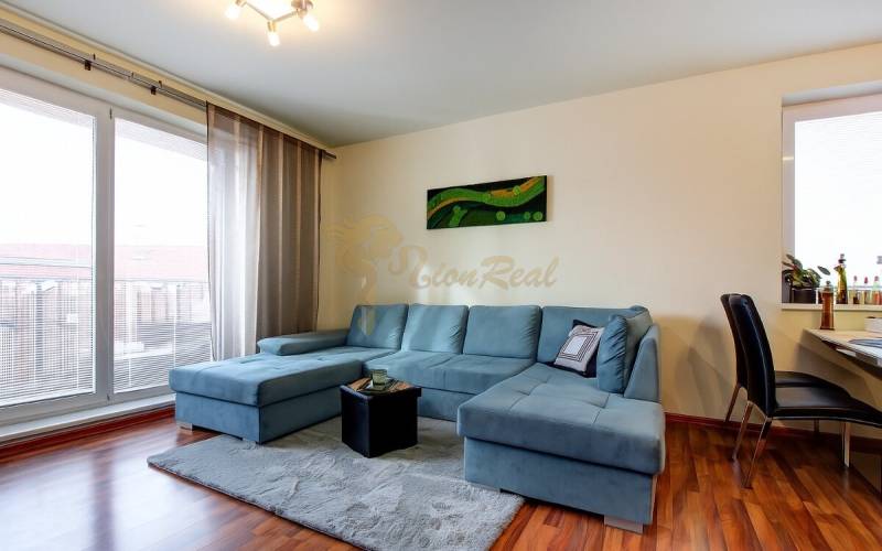 5-izb. byt, Krajinská, Podunajské Biskupice, 2.p./3 - Obývacia izba v 5 a viac izbovom byte s modrou sedačkou a podlahou s dreveným dekorom.