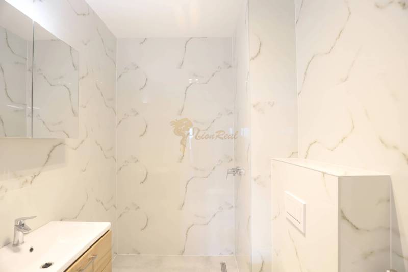 1-izb. byt v novostavbe v Ružinove, 4p./10 - Kúpeľňa so sprchovým kútom a umývadlom, obložená mramorovým dekorom v 1-izbovom byte.