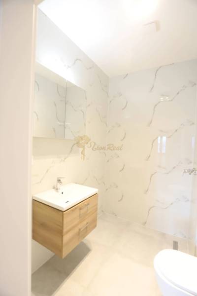 1-izb. byt v novostavbe v Ružinove, 4p./10 - Kúpeľňa 1-izbového bytu s dreveným umývadlovým kabinetom a mramorovými stenami.