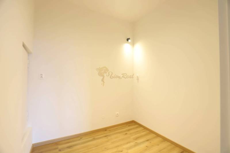 1-izb. byt v novostavbe v Ružinove, 4p./10 - Interiér 1-izbového bytu s bielymi stenami a podlahou s dreveným dekorom.