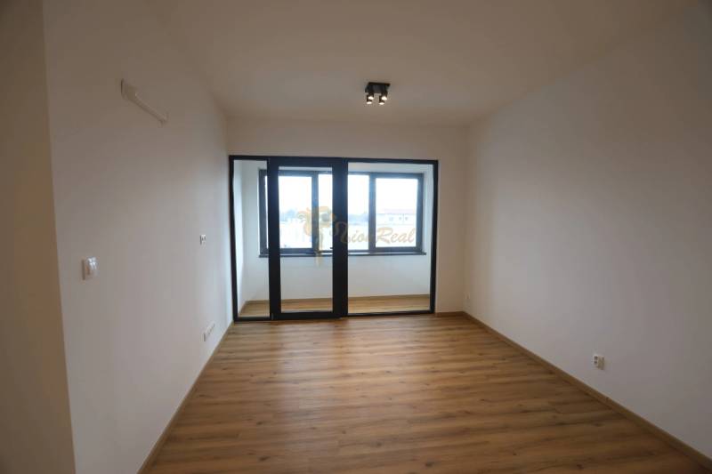 1-izb. byt v novostavbe v Ružinove, 4p./10 - Izba v 1-izbovom byte s presklenou stenou a podlahou s dreveným dekorom.