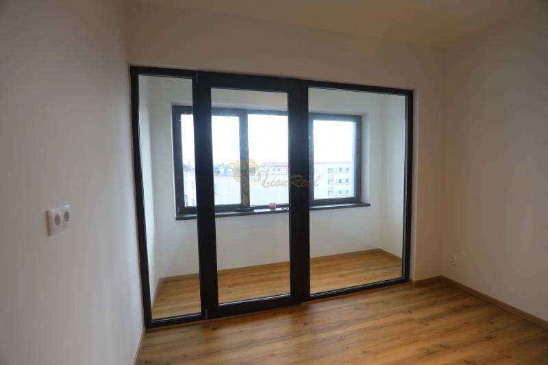 1-izb. byt v novostavbe v Ružinove, 4p./10 - Izba v 1-izbovom byte s podlahou s dreveným dekorom a veľkým oknom.