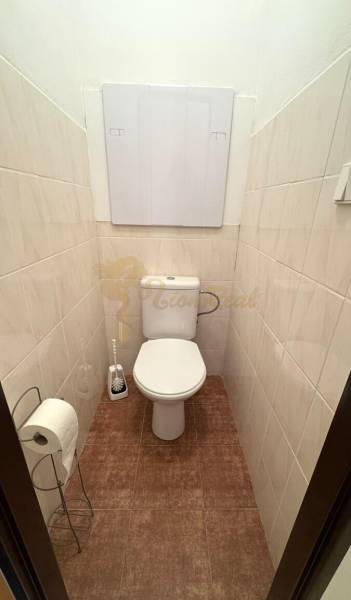 1-izb. byt, J.Stanislava, Karlova Ves, lodžia, 3.p./8 - Toaleta s béžovými obkladmi a tmavšou podlahou v 1-izbovom byte.