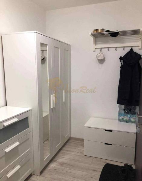 1,5 izb. byt s predzáhradkou, Podunajské Biskupice, projekt Oppidum - V 2-izbovom byte je biely šatník, vešiak a podlaha s dreveným dekorom.