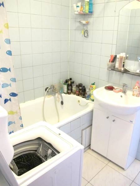 2-izb. byt pri Račianskom Mýte, balkón, 5.p./11 - Kúpeľňa v 2-izbovom byte s vaňou, práčkou a umývadlom, svetlomodré obklady.