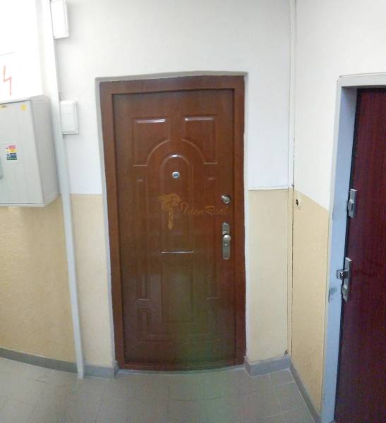 2-izb. byt pri Račianskom Mýte, balkón, 5.p./11 - Vchodové dvere 2-izbového bytu s hnedým dekorom v bytovom dome.