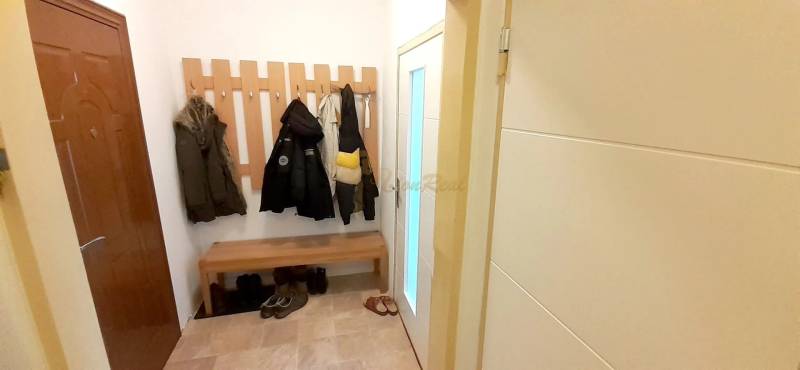 2-izb. byt pri Račianskom Mýte, balkón, 5.p./11 - V interiéri 2-izbového bytu je vešiaková stena, lavička a obuv.