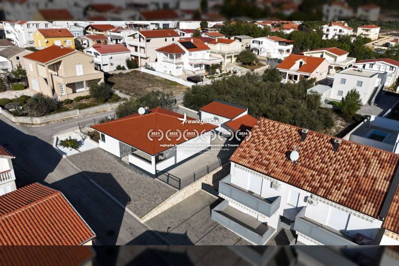 VRSI-MULO - jednoposchodový dom 103,07 m2 len 350 m od mora - Letecký pohľad na rodinné domy v ulici Mulo vo Vrsi s červenými strechami.