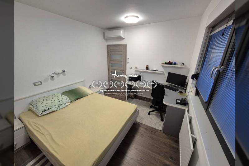 VRSI-MULO - jednoposchodový dom 103,07 m2 len 350 m od mora - Spálňa v rodinnom dome s písacím stolom a podlahou s dreveným dekorom.