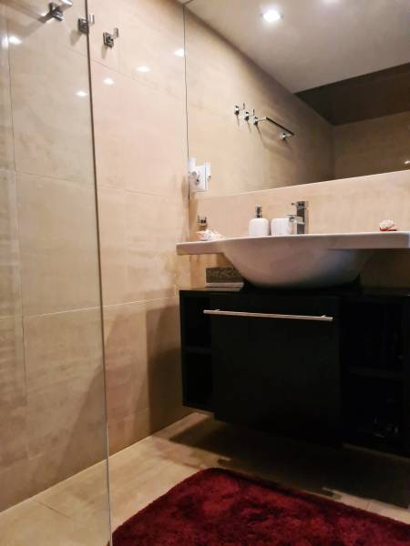 5-izb. dvojpodlažný rodinný dom, Rovinka - Kúpeľňa v rodinnom dome s umývadlom, skrinkou, zrkadlom a červeným kobercom.